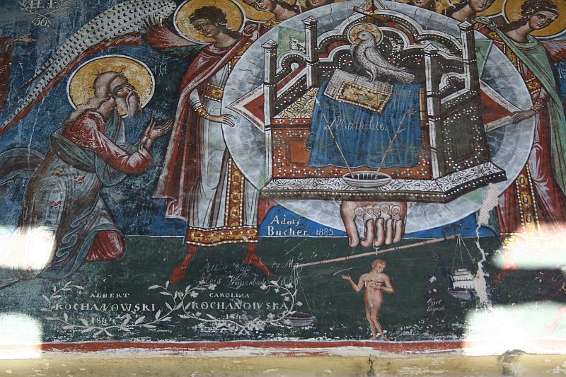 A detailed fresco in Romania depicts a biblical scene with vibrant colors and golden halos, featuring figures with stylized gestures and inscriptions, showcasing traditional orthodox iconography artistry.