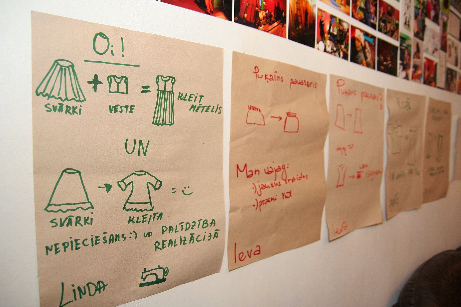 Handwritten instructions and diagrams on brown paper bags are pinned to a wall. They describe different clothing items in talka, showing illustrations of a shirt, a dress, and a skirt. Above the paper bags, colorful photographs are displayed in stylish Modes.