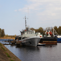 A Daugavgrīva boat docked in a body of water.