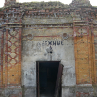An old brick building in Daugavgrīva with a sign on it.