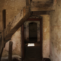 An eerie, dilapidated interior near the Daugav River, with warped wooden beams and crumbling walls, where a single shaft of light enters through a gap, suggesting a haunting abandonment and the passage