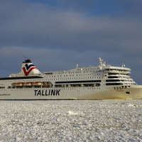 A large cruise ship navigating through the icy waters of Daugavgrīva during winter.