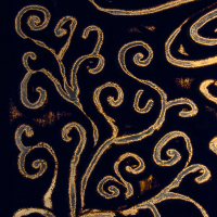 A dark artwork featuring intricate, swirling patterns drawn with a golden hue. The flowing lines form abstract, organic designs reminiscent of vines or tendrils, set against a deep black background, evoking the elegance of the Give and Get festival 2013's vibrant spirit with its striking contrast and decorative appearance.
