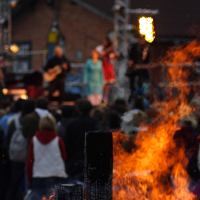 A group of people gathered around a bonfire at Dzelzs Vilks Ielīgo '09.