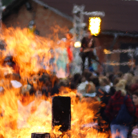 A group of people dancing around a bonfire.