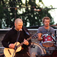 A man playing an acoustic guitar at Dzelzs Vilks Ielīgo '09 festival.