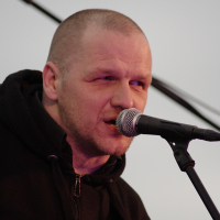A man singing into a microphone at the Dzelzs vilks ielīgo '09 music festival.