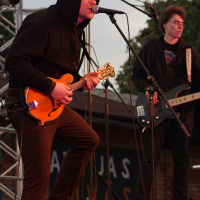 A man performing with an electric guitar and microphone.