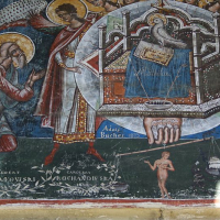 A detailed fresco in Romania depicts a biblical scene with vibrant colors and golden halos, featuring figures with stylized gestures and inscriptions, showcasing traditional orthodox iconography artistry.