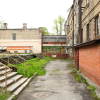 An Iļģuciems alleyway with stairs leading to a building.