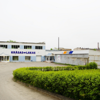 A blue building with a sign on it in Iļģuciems.