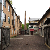 A Iļģuciems brick building with a chimney.
