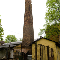 A brick building in Iļģuciems with a chimney.