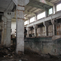 A building in Iļģuciems covered in rubble and dirt.