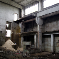 The inside of an Iļģuciems building with a lot of rubble.