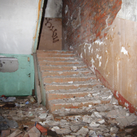 An abandoned building in Iļģuciems with a stairway.