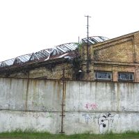 A graffiti-covered brick building in Iļģuciems.