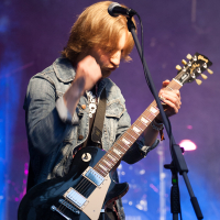 A man playing guitar on stage at Kilkim Žaibu 2012.