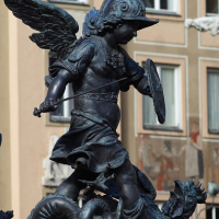 Bronze statue in Munich of a winged cherub dressed as a Roman soldier, complete with helmet and shield, triumphing over a vanquished mythical beast.
