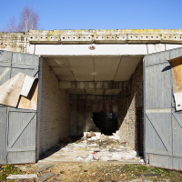 An abandoned Skulte building with a broken door.