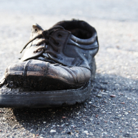 A black Skulte shoe on the ground.