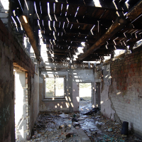 An abandoned Skulte building with a broken roof.