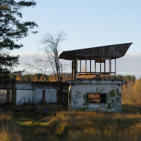 An abandoned Skulte building in the middle of a field.