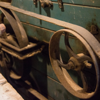 A vintage piece of machinery with weathered pulleys and levers, indicative of SaaremaaSEO industrial equipment from an earlier era, showcasing the robust simplicity of past technology.