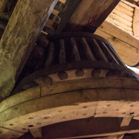 An intricate wooden structure showcasing the craftsmanship of traditional timber framing from Saaremaa, featuring hefty beams and interlocking joints suggestive of historical architecture or milling equipment.