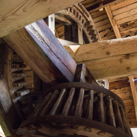 An intricate view of wooden gears and structure from the inside of a historic windmill in Saaremaa, showcasing the engineering of a bygone era.