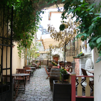 A Tallinn brick walkway with tables and chairs.