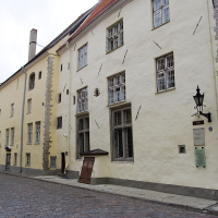 A yellow building in Tallinn on a cobblestone street.