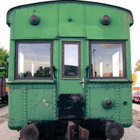 A green train car displayed at a train museum.