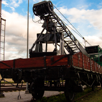 A train in a train museum with a crane attached to it.