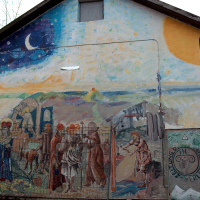 A vibrant mural adorns a building's gable end in Vilnius, depicting a blend of classic and whimsical elements, juxtaposing historical figures with celestial motifs under a starry sky.