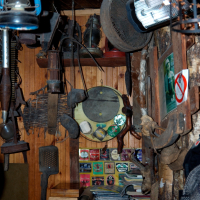 A cozy vintage corner filled with antiques, including a radio, hanging lamps, a lantern, and various collectibles on wooden walls in Vilnius, evoking nostalgia.