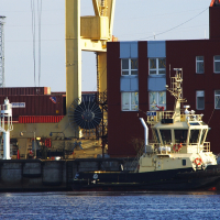 A Voleri boat docked next to a red building.