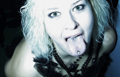 A Woman Is Posing With Her Tongue Out At A Halloween Party.
