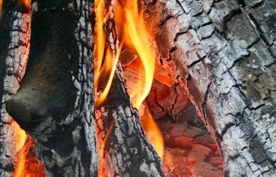 A Close Up Of A Fire With Flames And Logs.