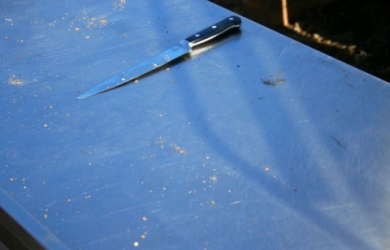 A Knife Rests On A Metal Table.