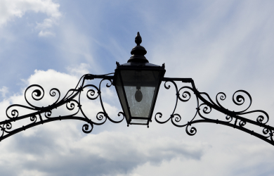 An Ornate Lantern Illuminating A Cloudy Sky.