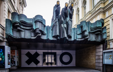 The Entrance To Lithuanian National Drama Theater Featuring A Statue Of A Man And A Woman.