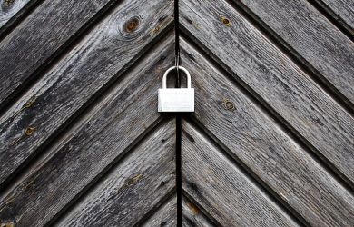 A Padlock Secures A Wooden Wall.