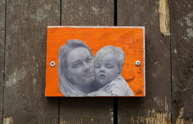 A Photo Of A Mother And Son Hanging On A Wooden Wall.