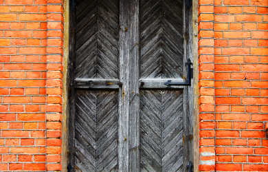 An Old Brick Building With A Wooden Door That Nobody Comes To Again.