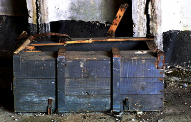 An Old Wooden Military Trunk Placed On A Concrete Floor.