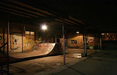 Skatepark At Night With A Skateboard Ramp.