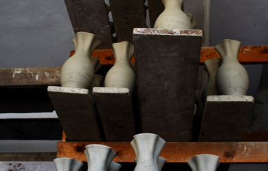 A Collection Of Vases Displayed On A Wooden Shelf.