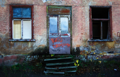 A Graffiti-Covered, Welcoming Building With A Door.
